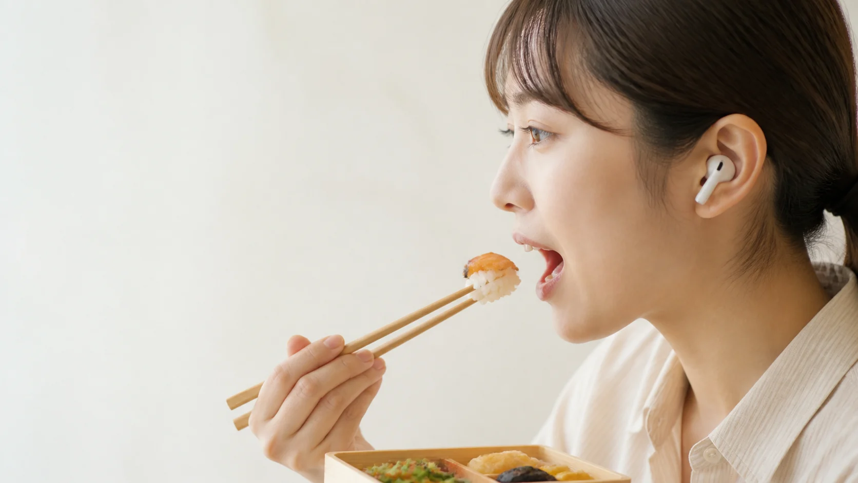 AirPods를 착용하고 점심을 먹는 여성